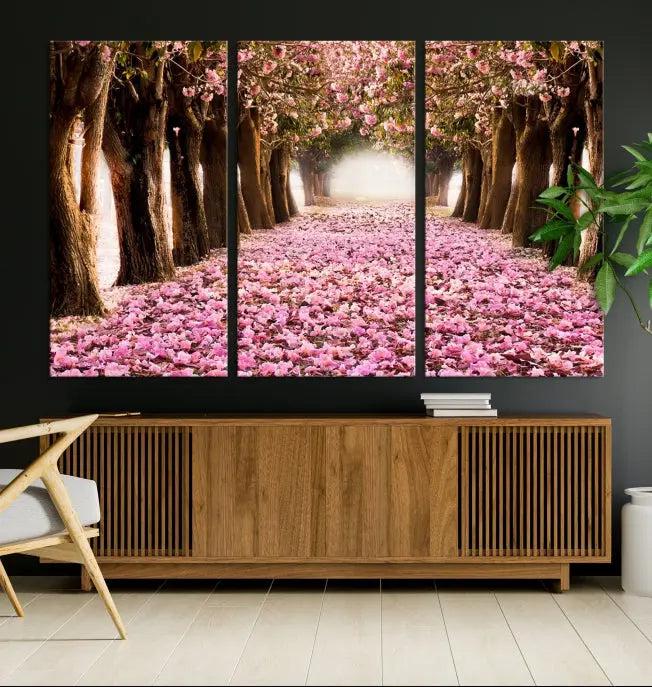 The Blossom Cherry Trees Wall Art Canvas Print, featuring a three-panel design on museum-quality canvas, showcases a tree-lined path with pink flowers. Each panel is gallery wrapped to add an extra layer of sophistication.