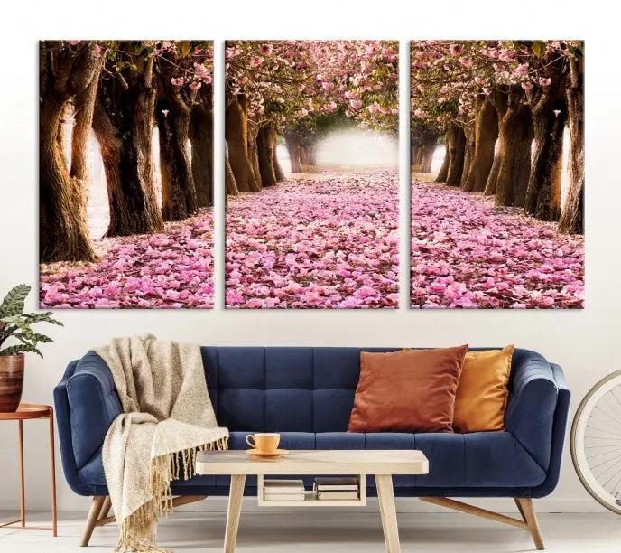 The Blossom Cherry Trees Wall Art Canvas Print, featuring a three-panel design on museum-quality canvas, showcases a tree-lined path with pink flowers. Each panel is gallery wrapped to add an extra layer of sophistication.