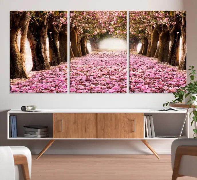 The Blossom Cherry Trees Wall Art Canvas Print, featuring a three-panel design on museum-quality canvas, showcases a tree-lined path with pink flowers. Each panel is gallery wrapped to add an extra layer of sophistication.