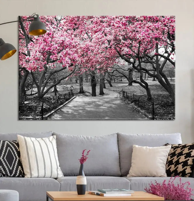 The "Blossom Cherry Trees and Leaves Wall Art Canvas Print" is a gallery-wrapped canvas that features a stunning depiction of a park path lined with pink blossoming trees in sepia tones. Its timeless beauty is preserved with a UV-protective coating.