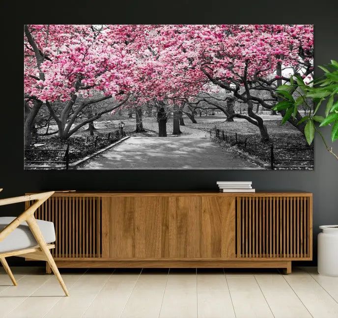 The "Blossom Cherry Trees and Leaves Wall Art Canvas Print" is a gallery-wrapped canvas that features a stunning depiction of a park path lined with pink blossoming trees in sepia tones. Its timeless beauty is preserved with a UV-protective coating.