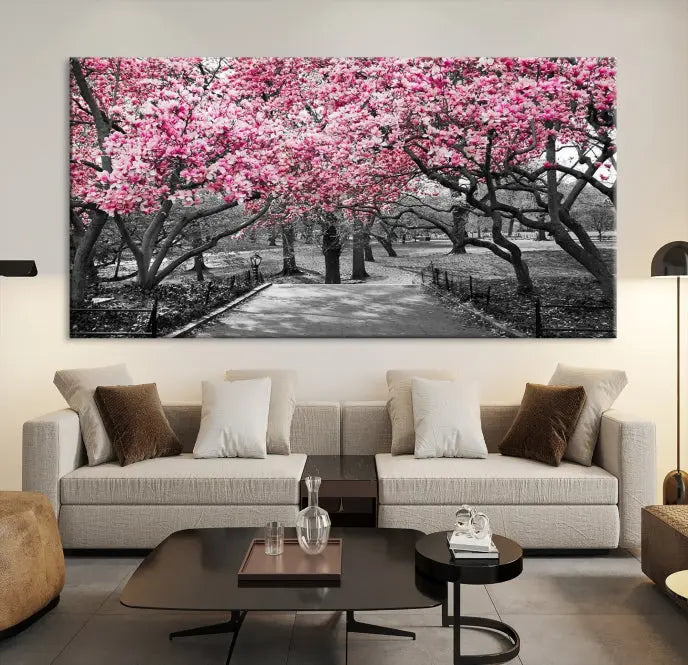 The "Blossom Cherry Trees and Leaves Wall Art Canvas Print" is a gallery-wrapped canvas that features a stunning depiction of a park path lined with pink blossoming trees in sepia tones. Its timeless beauty is preserved with a UV-protective coating.