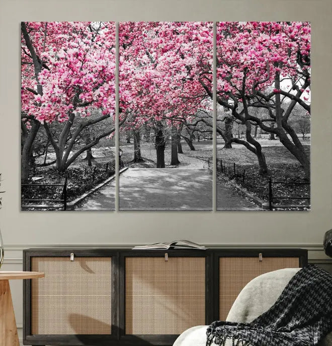 The "Blossom Cherry Trees and Leaves Wall Art Canvas Print" is a gallery-wrapped canvas that features a stunning depiction of a park path lined with pink blossoming trees in sepia tones. Its timeless beauty is preserved with a UV-protective coating.