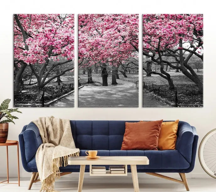 The "Blossom Cherry Trees and Leaves Wall Art Canvas Print" is a gallery-wrapped canvas that features a stunning depiction of a park path lined with pink blossoming trees in sepia tones. Its timeless beauty is preserved with a UV-protective coating.