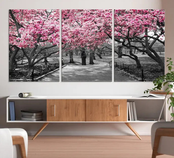 The "Blossom Cherry Trees and Leaves Wall Art Canvas Print" is a gallery-wrapped canvas that features a stunning depiction of a park path lined with pink blossoming trees in sepia tones. Its timeless beauty is preserved with a UV-protective coating.