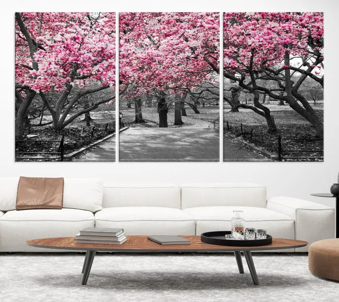 The "Blossom Cherry Trees and Leaves Wall Art Canvas Print" is a gallery-wrapped canvas that features a stunning depiction of a park path lined with pink blossoming trees in sepia tones. Its timeless beauty is preserved with a UV-protective coating.