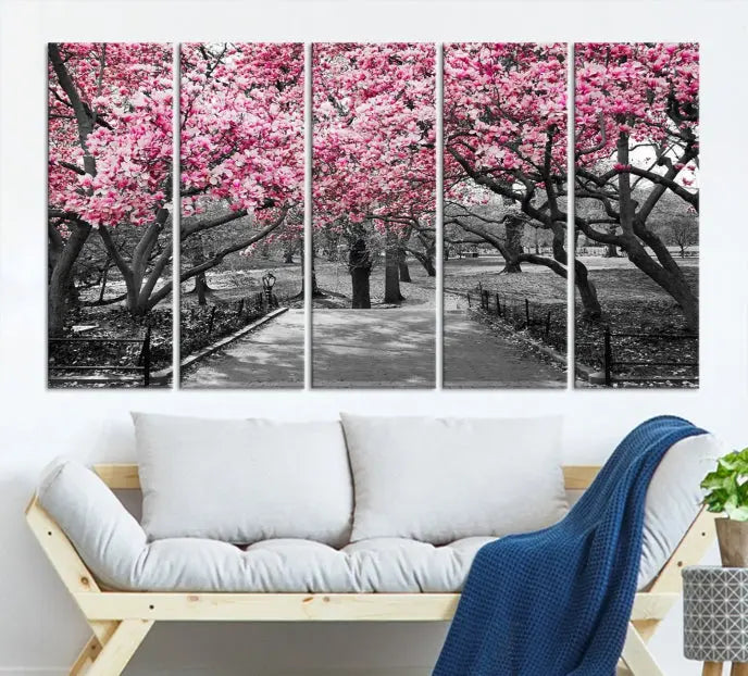 The "Blossom Cherry Trees and Leaves Wall Art Canvas Print" is a gallery-wrapped canvas that features a stunning depiction of a park path lined with pink blossoming trees in sepia tones. Its timeless beauty is preserved with a UV-protective coating.