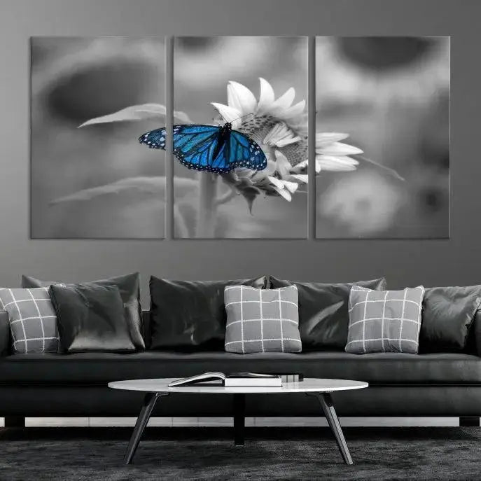 The modern living room showcases the Blue Butterfly Black and White Canvas Wall Art as a triptych. These museum-quality canvases, equipped with UV-protective coating and ready to hang, add both elegance and durability to the decor.