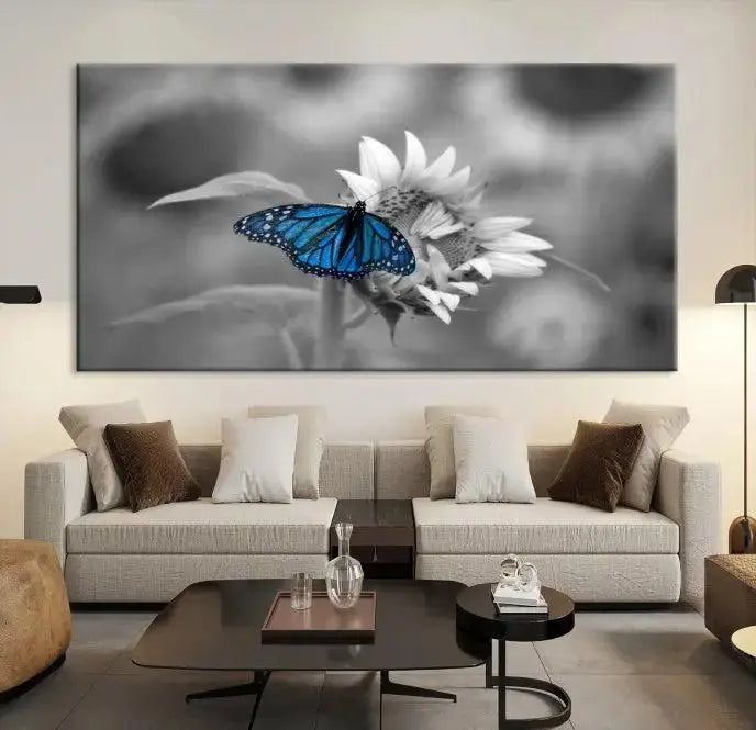 The modern living room showcases the Blue Butterfly Black and White Canvas Wall Art as a triptych. These museum-quality canvases, equipped with UV-protective coating and ready to hang, add both elegance and durability to the decor.