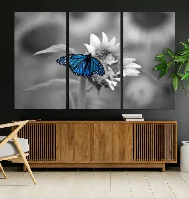 The modern living room showcases the Blue Butterfly Black and White Canvas Wall Art as a triptych. These museum-quality canvases, equipped with UV-protective coating and ready to hang, add both elegance and durability to the decor.