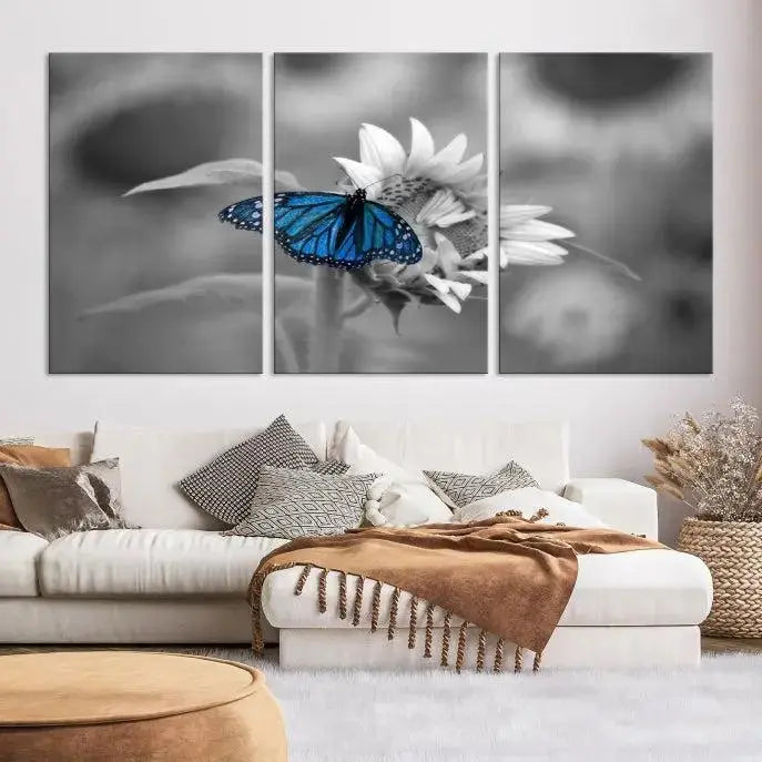 The modern living room showcases the Blue Butterfly Black and White Canvas Wall Art as a triptych. These museum-quality canvases, equipped with UV-protective coating and ready to hang, add both elegance and durability to the decor.