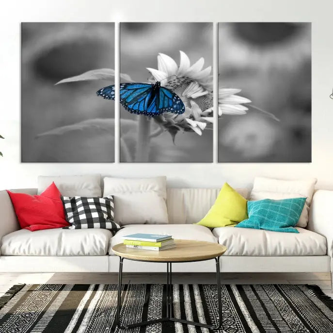 The modern living room showcases the Blue Butterfly Black and White Canvas Wall Art as a triptych. These museum-quality canvases, equipped with UV-protective coating and ready to hang, add both elegance and durability to the decor.