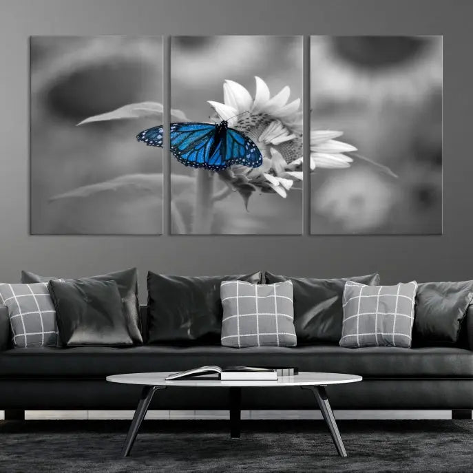 The modern living room showcases the Blue Butterfly Black and White Canvas Wall Art as a triptych. These museum-quality canvases, equipped with UV-protective coating and ready to hang, add both elegance and durability to the decor.