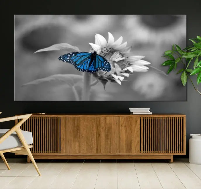 The modern living room showcases the Blue Butterfly Black and White Canvas Wall Art as a triptych. These museum-quality canvases, equipped with UV-protective coating and ready to hang, add both elegance and durability to the decor.