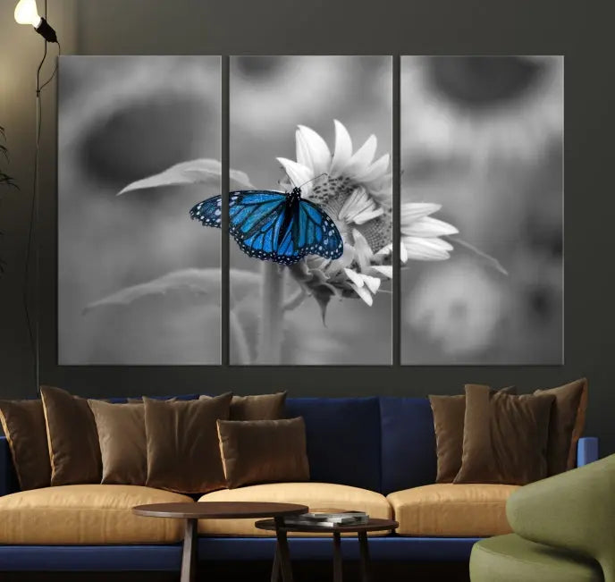 The modern living room showcases the Blue Butterfly Black and White Canvas Wall Art as a triptych. These museum-quality canvases, equipped with UV-protective coating and ready to hang, add both elegance and durability to the decor.