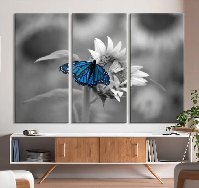 The modern living room showcases the Blue Butterfly Black and White Canvas Wall Art as a triptych. These museum-quality canvases, equipped with UV-protective coating and ready to hang, add both elegance and durability to the decor.