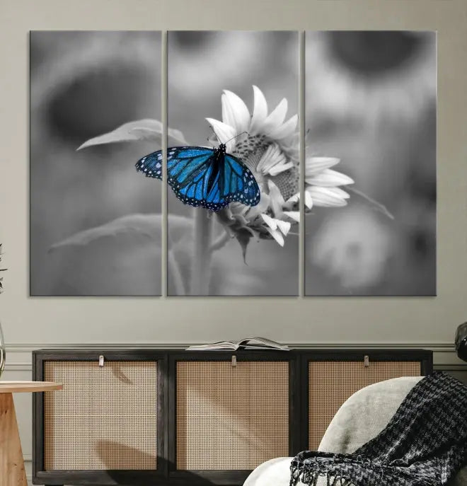 The modern living room showcases the Blue Butterfly Black and White Canvas Wall Art as a triptych. These museum-quality canvases, equipped with UV-protective coating and ready to hang, add both elegance and durability to the decor.