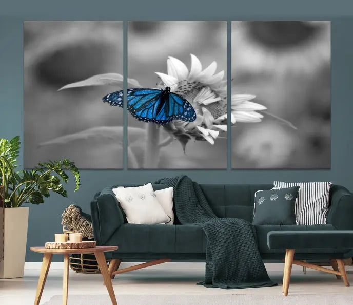 The modern living room showcases the Blue Butterfly Black and White Canvas Wall Art as a triptych. These museum-quality canvases, equipped with UV-protective coating and ready to hang, add both elegance and durability to the decor.