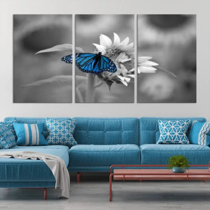 The modern living room showcases the Blue Butterfly Black and White Canvas Wall Art as a triptych. These museum-quality canvases, equipped with UV-protective coating and ready to hang, add both elegance and durability to the decor.