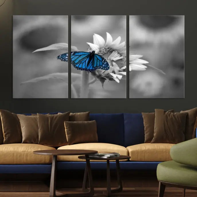 The modern living room showcases the Blue Butterfly Black and White Canvas Wall Art as a triptych. These museum-quality canvases, equipped with UV-protective coating and ready to hang, add both elegance and durability to the decor.