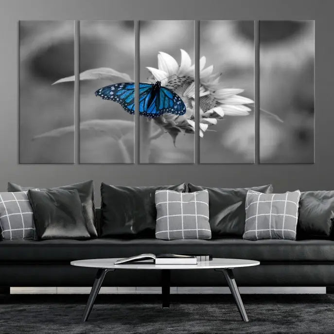 The modern living room showcases the Blue Butterfly Black and White Canvas Wall Art as a triptych. These museum-quality canvases, equipped with UV-protective coating and ready to hang, add both elegance and durability to the decor.