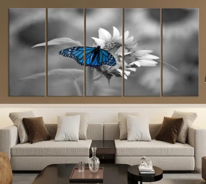 The modern living room showcases the Blue Butterfly Black and White Canvas Wall Art as a triptych. These museum-quality canvases, equipped with UV-protective coating and ready to hang, add both elegance and durability to the decor.