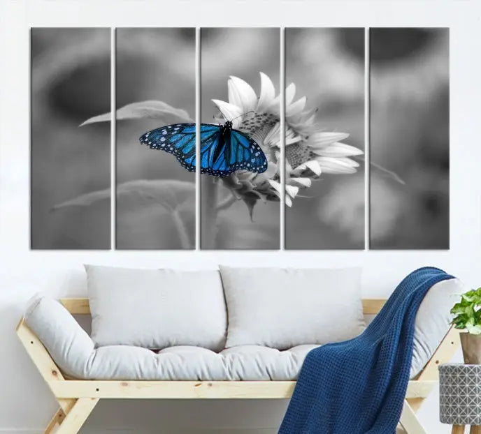 The modern living room showcases the Blue Butterfly Black and White Canvas Wall Art as a triptych. These museum-quality canvases, equipped with UV-protective coating and ready to hang, add both elegance and durability to the decor.