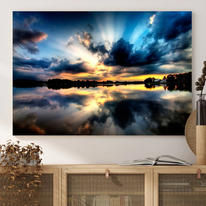 The "Blue Clouds and Sunshine Sunset Wall Art Canvas Print" perfectly captures a stunning sunset over a calm lake, where dramatic clouds and sunrays are beautifully reflected in the water. This museum-quality, ready-to-hang piece flawlessly preserves nature's breathtaking moment.