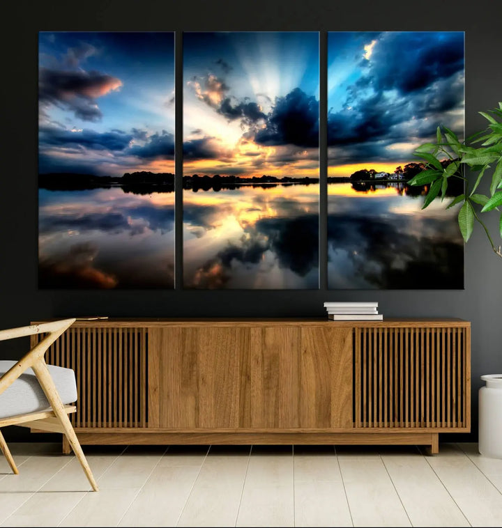 The "Blue Clouds and Sunshine Sunset Wall Art Canvas Print" perfectly captures a stunning sunset over a calm lake, where dramatic clouds and sunrays are beautifully reflected in the water. This museum-quality, ready-to-hang piece flawlessly preserves nature's breathtaking moment.