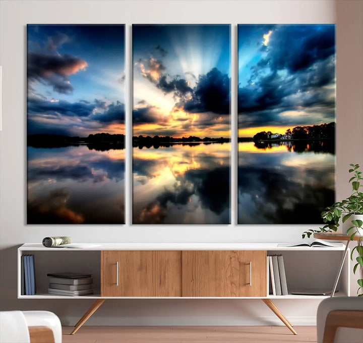 The "Blue Clouds and Sunshine Sunset Wall Art Canvas Print" perfectly captures a stunning sunset over a calm lake, where dramatic clouds and sunrays are beautifully reflected in the water. This museum-quality, ready-to-hang piece flawlessly preserves nature's breathtaking moment.