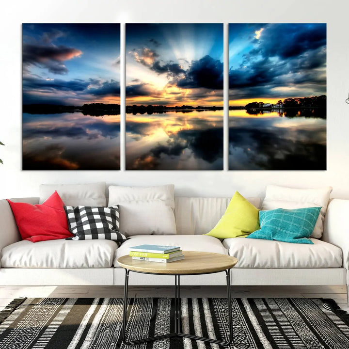 The "Blue Clouds and Sunshine Sunset Wall Art Canvas Print" perfectly captures a stunning sunset over a calm lake, where dramatic clouds and sunrays are beautifully reflected in the water. This museum-quality, ready-to-hang piece flawlessly preserves nature's breathtaking moment.