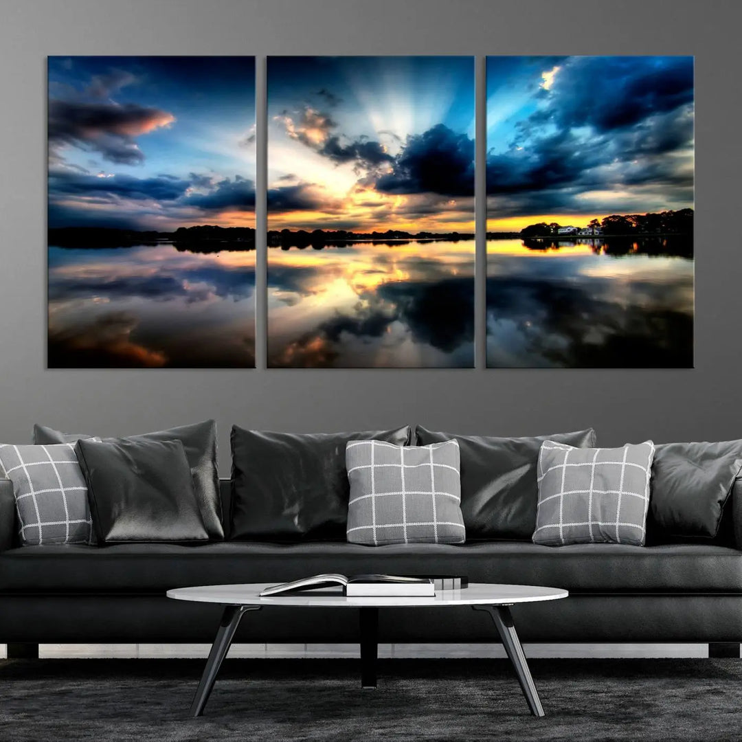 The "Blue Clouds and Sunshine Sunset Wall Art Canvas Print" perfectly captures a stunning sunset over a calm lake, where dramatic clouds and sunrays are beautifully reflected in the water. This museum-quality, ready-to-hang piece flawlessly preserves nature's breathtaking moment.