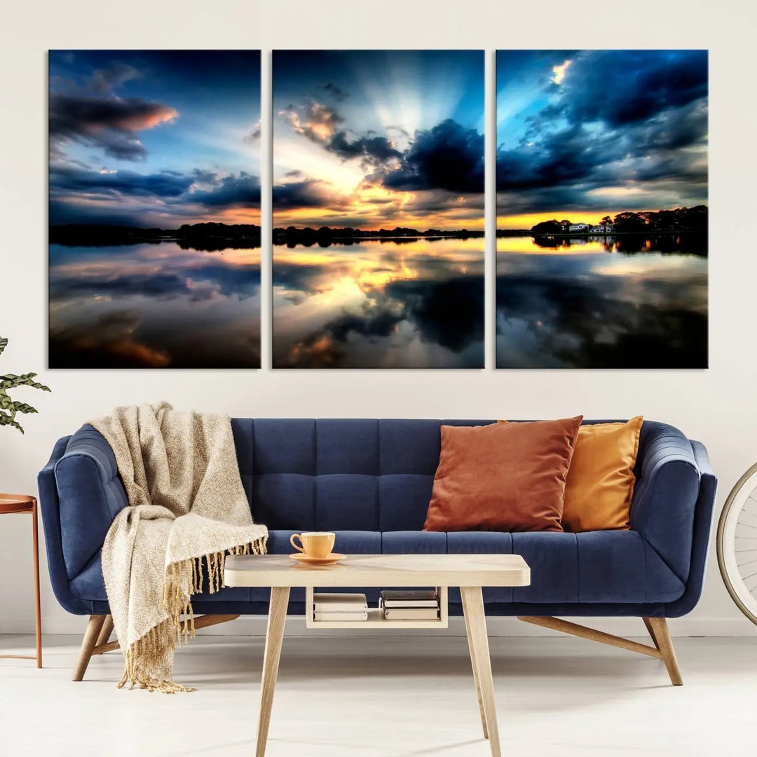 The "Blue Clouds and Sunshine Sunset Wall Art Canvas Print" perfectly captures a stunning sunset over a calm lake, where dramatic clouds and sunrays are beautifully reflected in the water. This museum-quality, ready-to-hang piece flawlessly preserves nature's breathtaking moment.