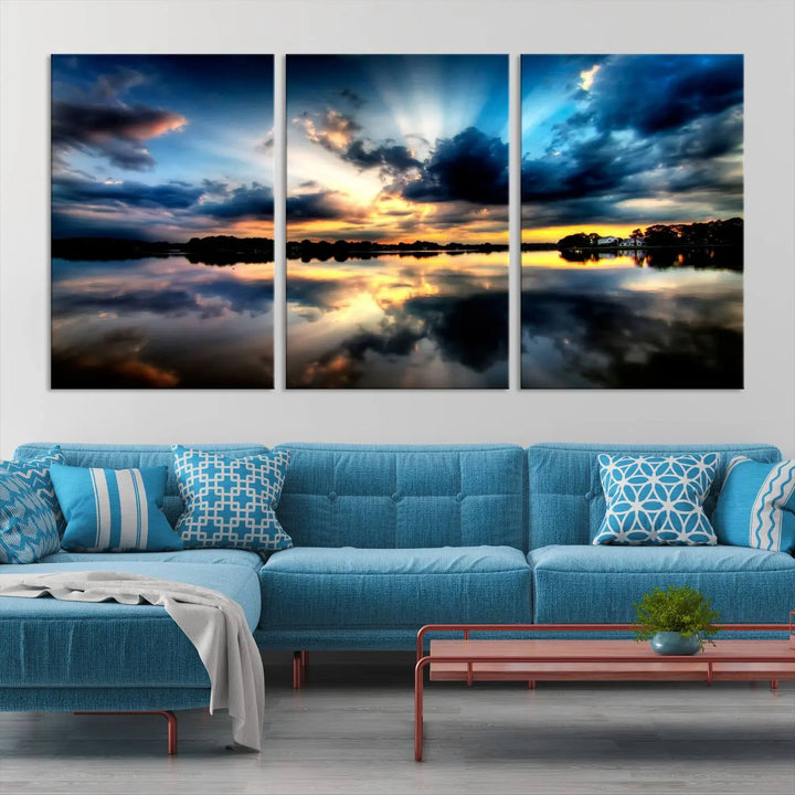 The "Blue Clouds and Sunshine Sunset Wall Art Canvas Print" perfectly captures a stunning sunset over a calm lake, where dramatic clouds and sunrays are beautifully reflected in the water. This museum-quality, ready-to-hang piece flawlessly preserves nature's breathtaking moment.