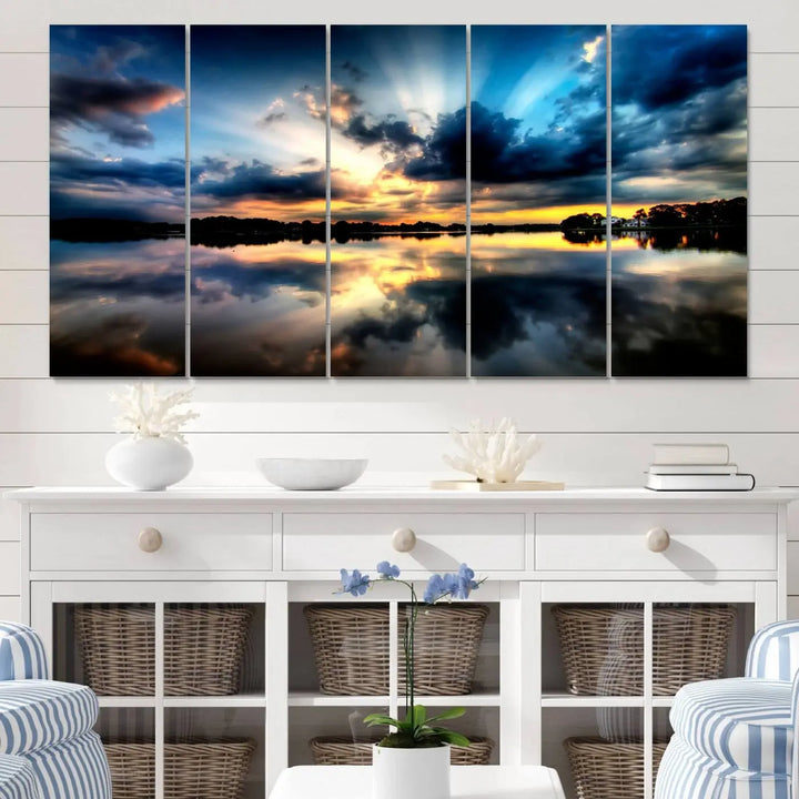 The "Blue Clouds and Sunshine Sunset Wall Art Canvas Print" perfectly captures a stunning sunset over a calm lake, where dramatic clouds and sunrays are beautifully reflected in the water. This museum-quality, ready-to-hang piece flawlessly preserves nature's breathtaking moment.