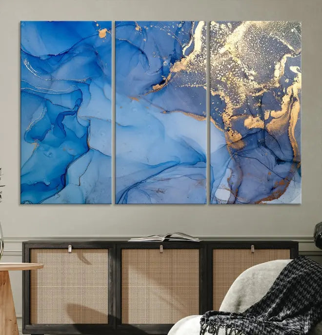 Modern living room featuring the Blue Gold Marble Fluid Canvas Wall Art that showcases three-panel abstract designs in blue and gold on museum-quality canvas. These art pieces are professionally hand-assembled for an exquisite finish.