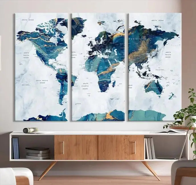 The modern living room showcases the Blue Green World Map Wall Art Canvas Print, a captivating three-panel artwork crafted on museum-quality canvases with a UV-protective coating.