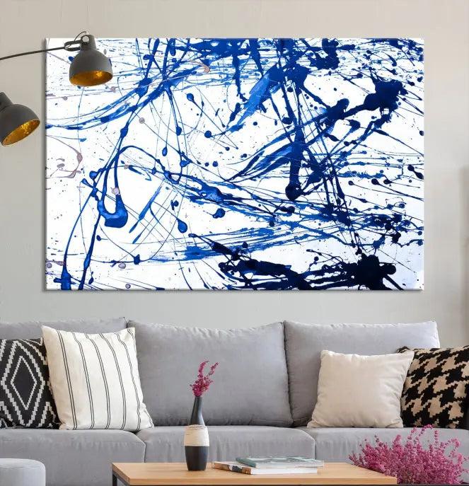 The Blue Ink Splash Wall Art Canvas Print Success is a triptych abstract piece featuring blue splatters on a clean white background. Crafted on gallery-wrapped canvases of museum quality, it includes a UV-protective coating to maintain its vibrant allure for years.