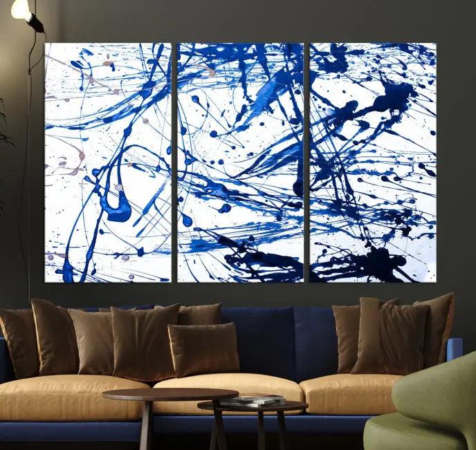 The Blue Ink Splash Wall Art Canvas Print Success is a triptych abstract piece featuring blue splatters on a clean white background. Crafted on gallery-wrapped canvases of museum quality, it includes a UV-protective coating to maintain its vibrant allure for years.