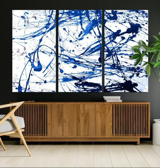 The Blue Ink Splash Wall Art Canvas Print Success is a triptych abstract piece featuring blue splatters on a clean white background. Crafted on gallery-wrapped canvases of museum quality, it includes a UV-protective coating to maintain its vibrant allure for years.