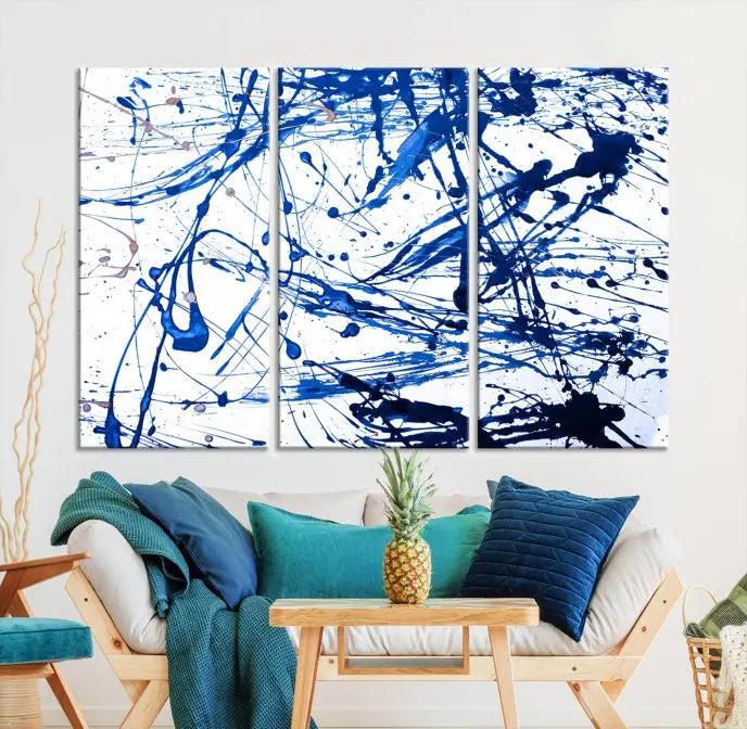 The Blue Ink Splash Wall Art Canvas Print Success is a triptych abstract piece featuring blue splatters on a clean white background. Crafted on gallery-wrapped canvases of museum quality, it includes a UV-protective coating to maintain its vibrant allure for years.