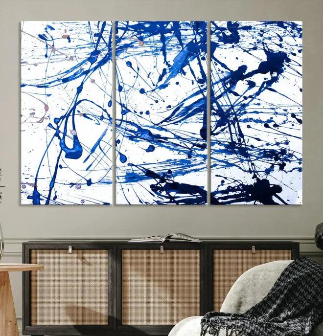 The Blue Ink Splash Wall Art Canvas Print Success is a triptych abstract piece featuring blue splatters on a clean white background. Crafted on gallery-wrapped canvases of museum quality, it includes a UV-protective coating to maintain its vibrant allure for years.