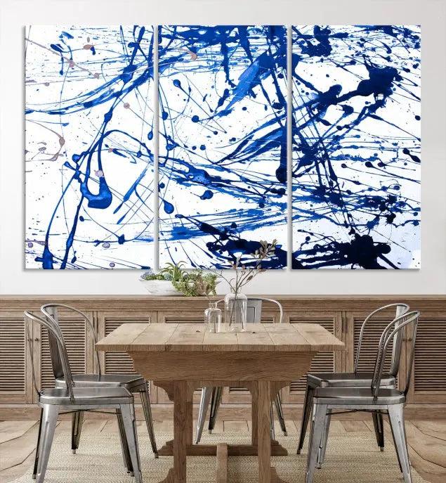 The Blue Ink Splash Wall Art Canvas Print Success is a triptych abstract piece featuring blue splatters on a clean white background. Crafted on gallery-wrapped canvases of museum quality, it includes a UV-protective coating to maintain its vibrant allure for years.