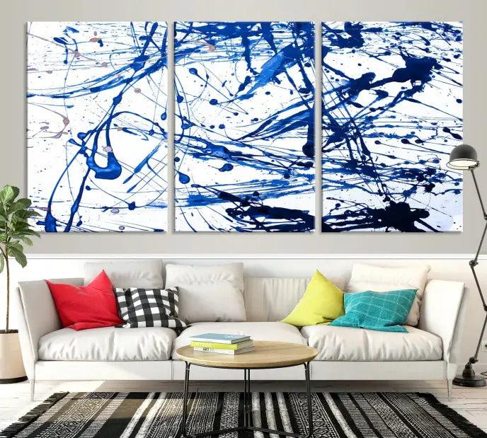 The Blue Ink Splash Wall Art Canvas Print Success is a triptych abstract piece featuring blue splatters on a clean white background. Crafted on gallery-wrapped canvases of museum quality, it includes a UV-protective coating to maintain its vibrant allure for years.