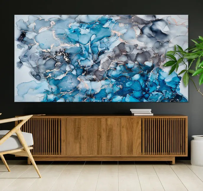 The "Blue Marble Fluid Effect Wall Art Abstract Canvas Wall Art Print" is a triptych that showcases captivating blue and gray abstract patterns on museum-quality canvas. It is enhanced with a UV-protective coating to maintain its vivid colors over time.