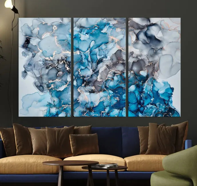 The "Blue Marble Fluid Effect Wall Art Abstract Canvas Wall Art Print" is a triptych that showcases captivating blue and gray abstract patterns on museum-quality canvas. It is enhanced with a UV-protective coating to maintain its vivid colors over time.