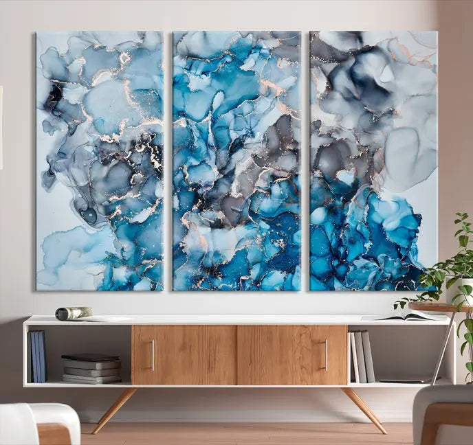 The "Blue Marble Fluid Effect Wall Art Abstract Canvas Wall Art Print" is a triptych that showcases captivating blue and gray abstract patterns on museum-quality canvas. It is enhanced with a UV-protective coating to maintain its vivid colors over time.