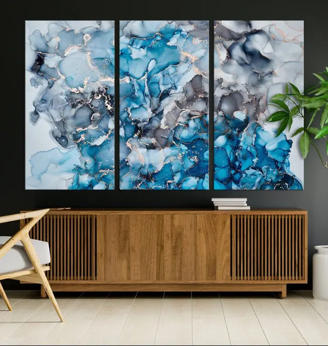 The "Blue Marble Fluid Effect Wall Art Abstract Canvas Wall Art Print" is a triptych that showcases captivating blue and gray abstract patterns on museum-quality canvas. It is enhanced with a UV-protective coating to maintain its vivid colors over time.