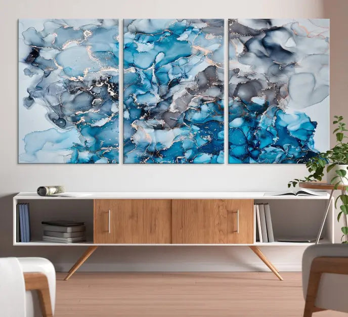 The "Blue Marble Fluid Effect Wall Art Abstract Canvas Wall Art Print" is a triptych that showcases captivating blue and gray abstract patterns on museum-quality canvas. It is enhanced with a UV-protective coating to maintain its vivid colors over time.