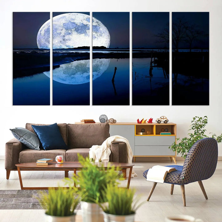 A mesmerizing Blue Moon Wall Art Canvas Print, depicting a lake landscape with a silhouetted tree, is beautifully presented on museum-quality canvas. This gallery-wrapped artwork, protected by a UV-coating to preserve its stunning details, stands out as an exquisite piece in the room.